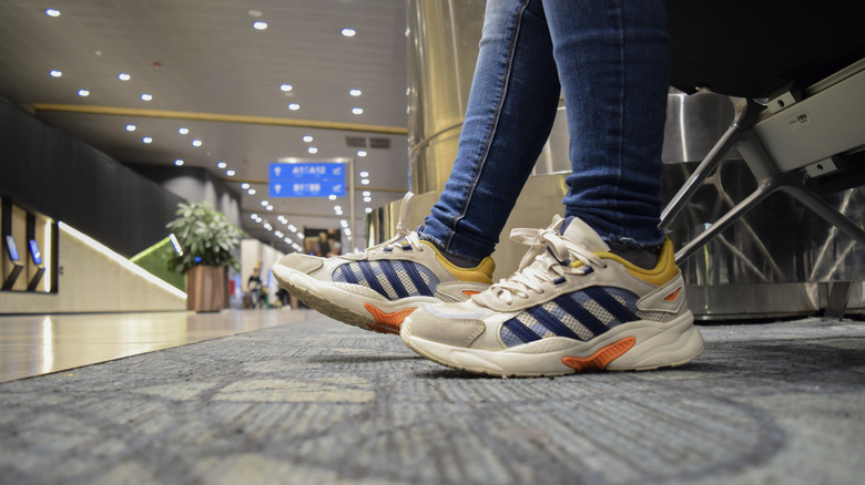 Traveler's sneakers on airport terminal carpet