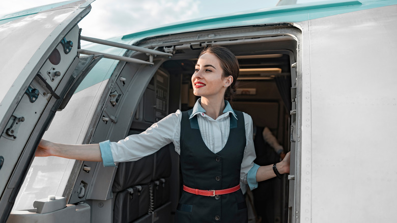flight attendant opening airplane door