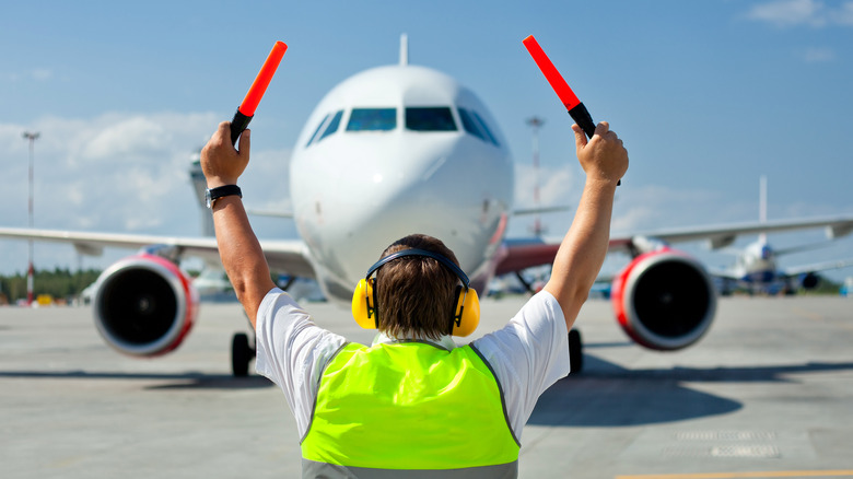 ground crew directing airplane