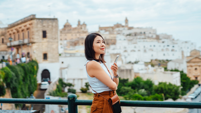 Woman holding phone in Italy