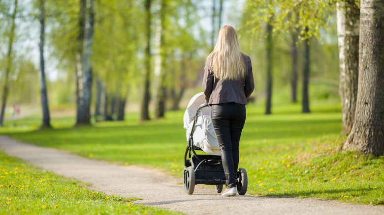 mother walking stroller in park