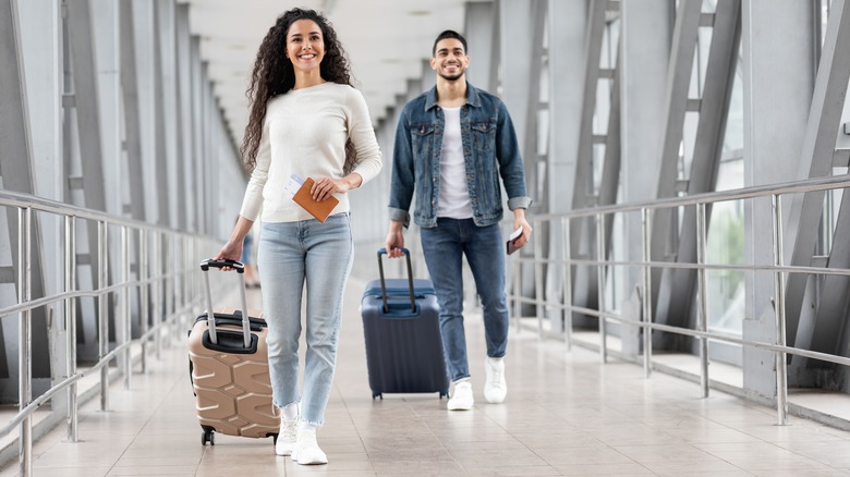Couple traveling with carry-on suitcases