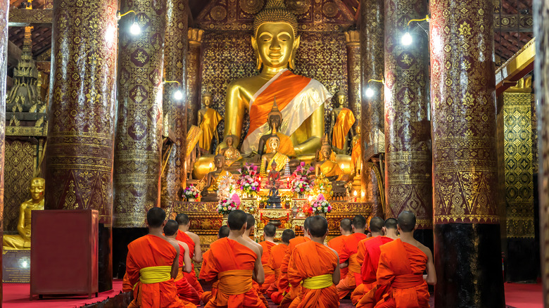 Praying monks at Wat Xieng Thong temple