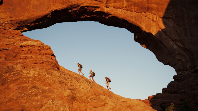 Hikers walking along stone arch