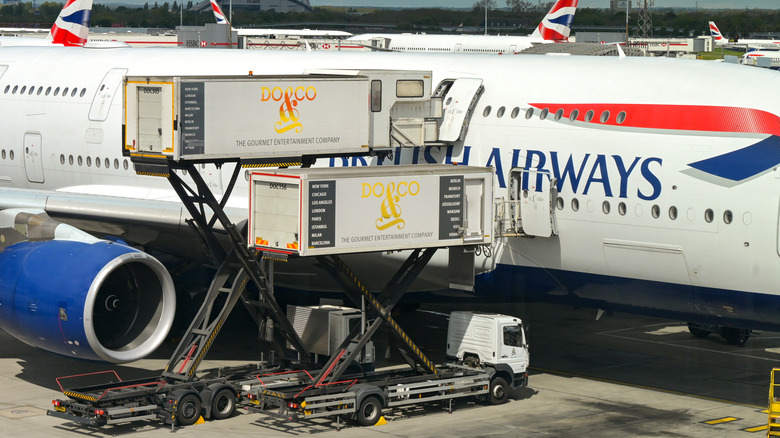 Two catering trucks delivering food for a British Airways flight