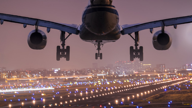 plane landing over lit runway