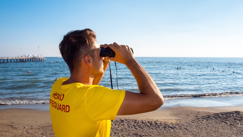 beach lifeguard watching swimmers 