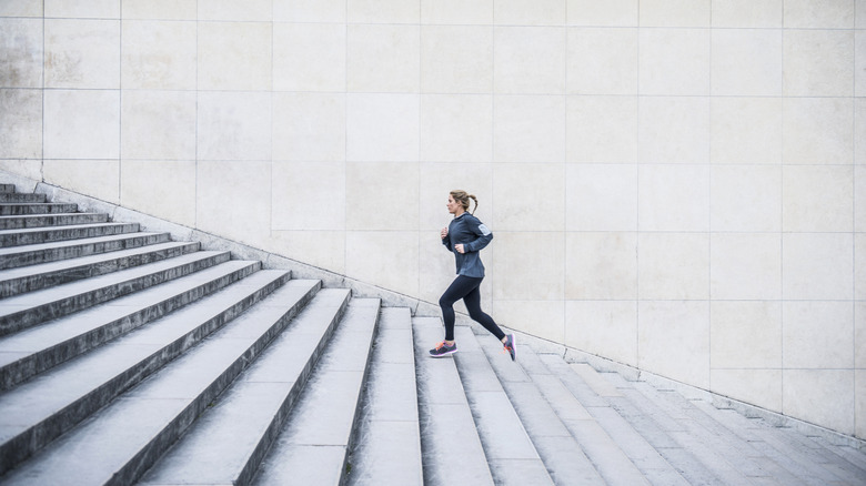 A woman runs up a long set of steps