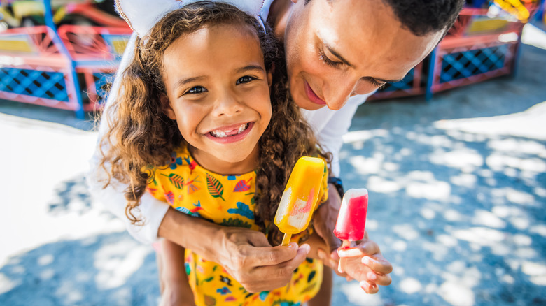 Girl and dad eating popsicle