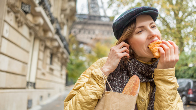 Woman eating croissant