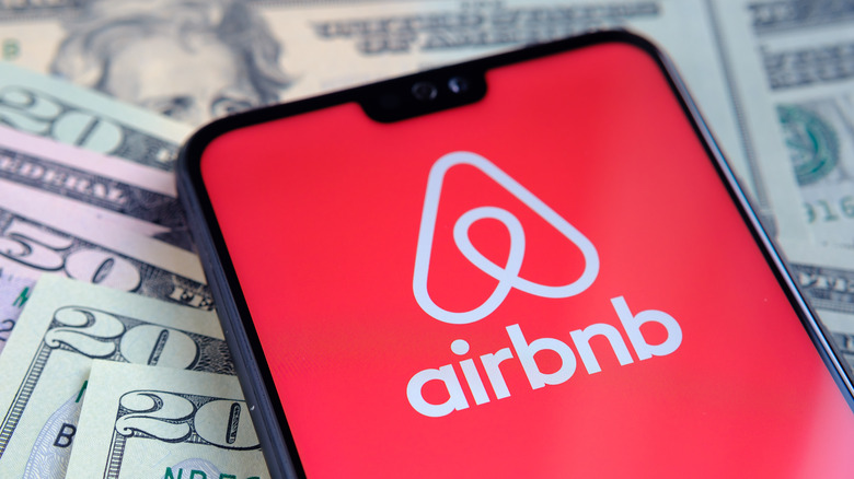 Airbnb logo on phone and cash