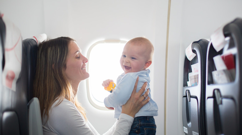 woman holding baby on airplane