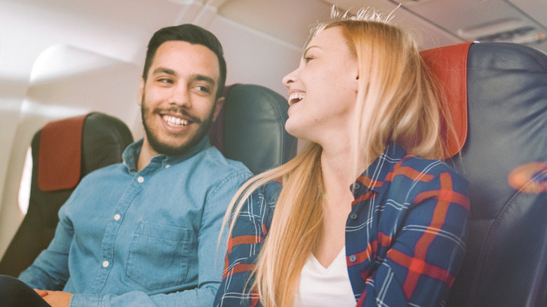 woman talking to man on airplane