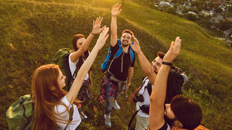 Travel group with hands raised