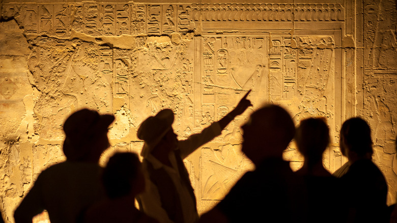 Tour guide showing Egyptian hieroglyphics