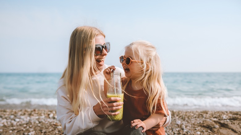 Mother and daughter sharing smoothie