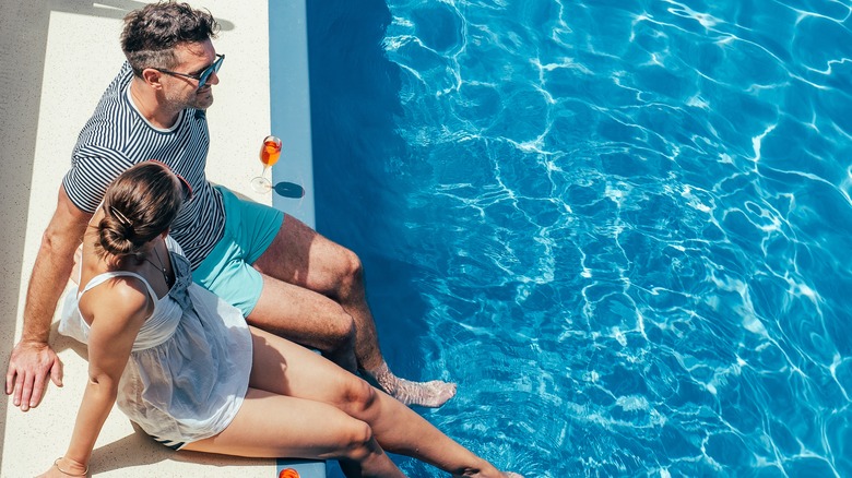 Couple relaxing by pool 