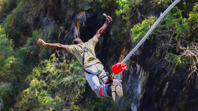Man bungee jumping off cliff