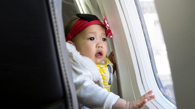Baby looking out a plane window