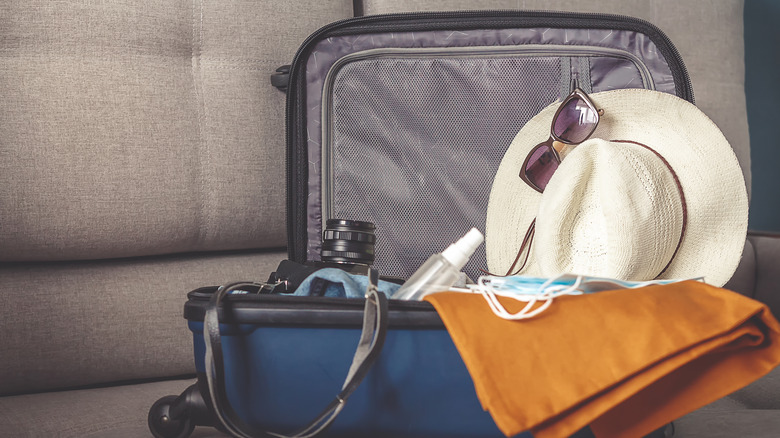 suitcase with hat, masks, and camera