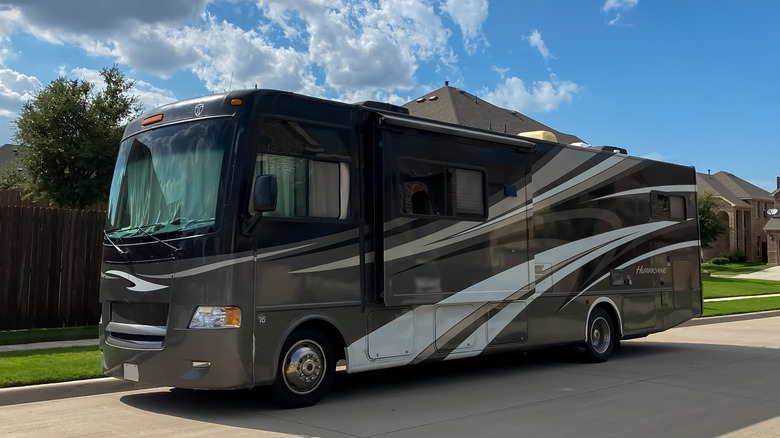 a large RV against blue sky and clouds