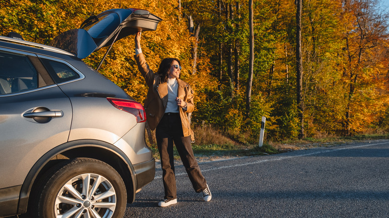 Woman closing car trunk