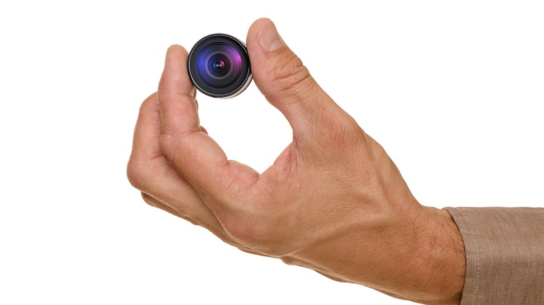 Hand holding a small camera lens
