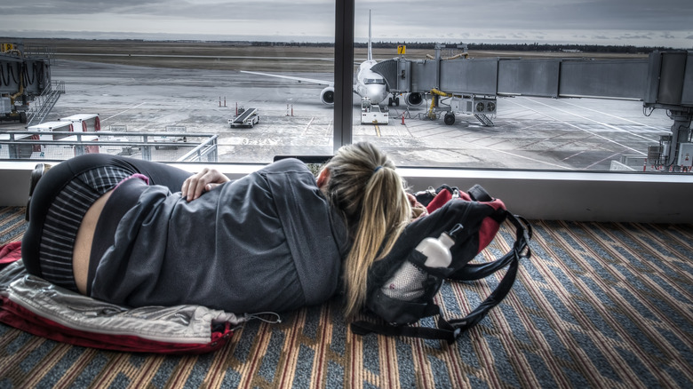woman sleeping on airport floor