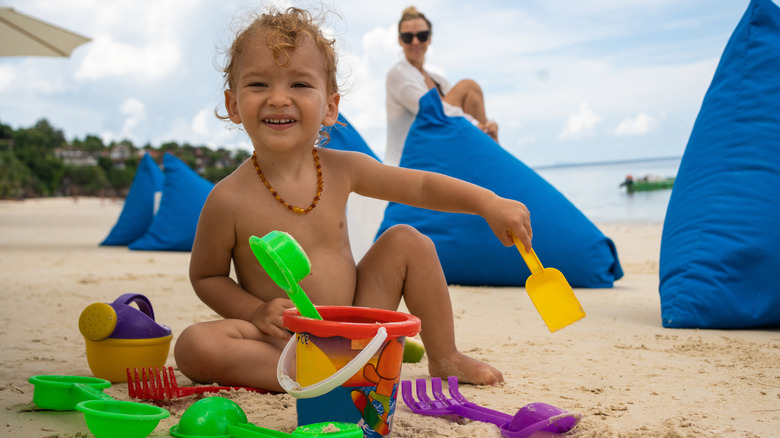 Baby playing with toys in the sand