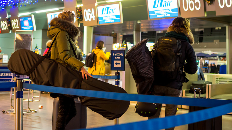 person checking in skis at airport