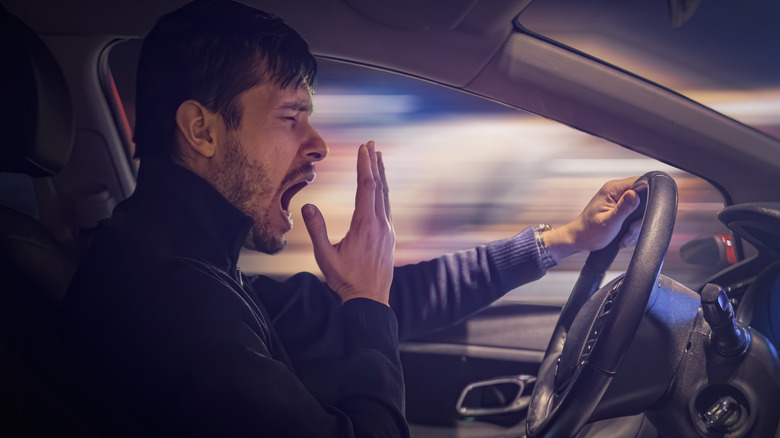 man yawning while driving
