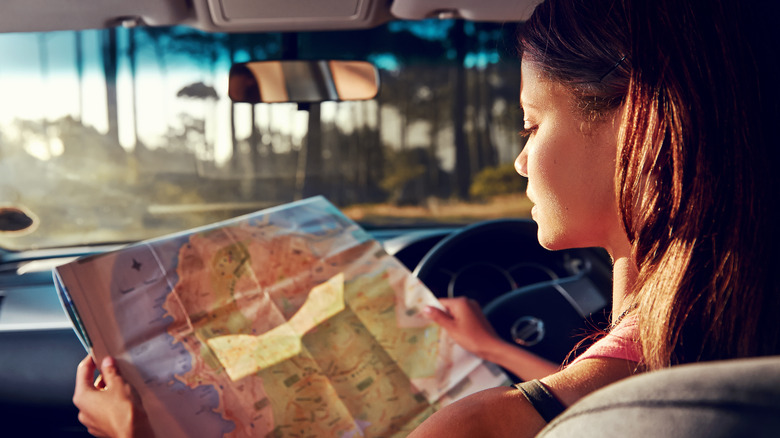 woman and map at sunset