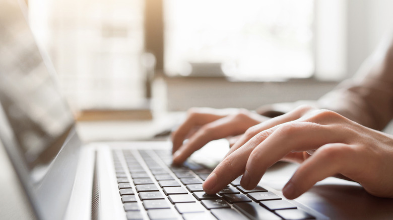 typing hands on laptop