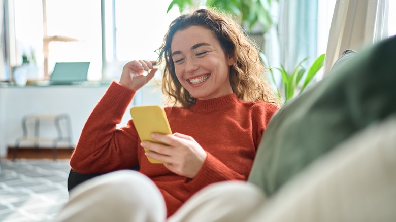 Woman looking at a smartphone while smiling