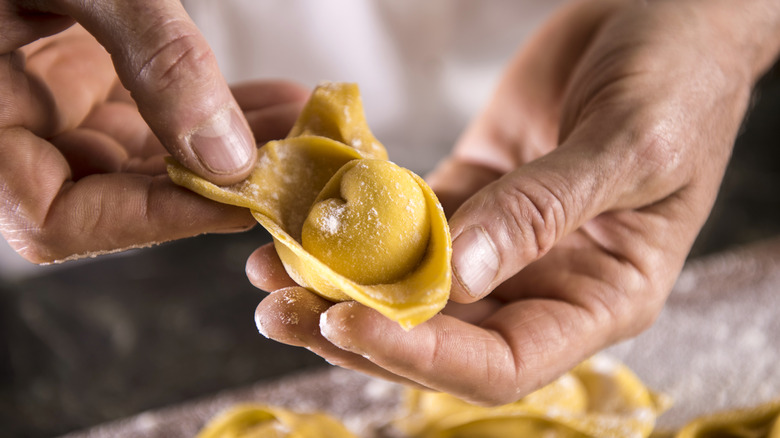 Hands making fresh tortellini
