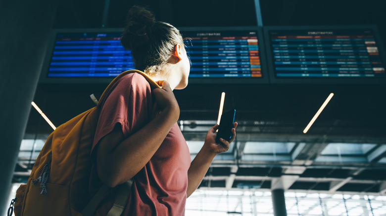 Traveler checking airport departure schedule