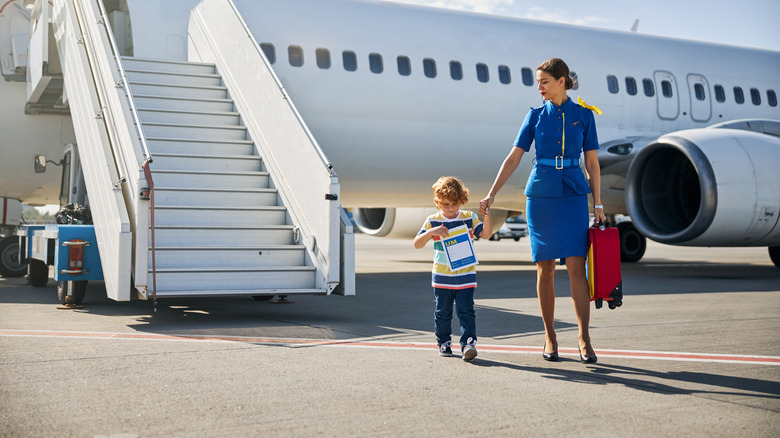 An unaccompanied minor with a flight attendant.