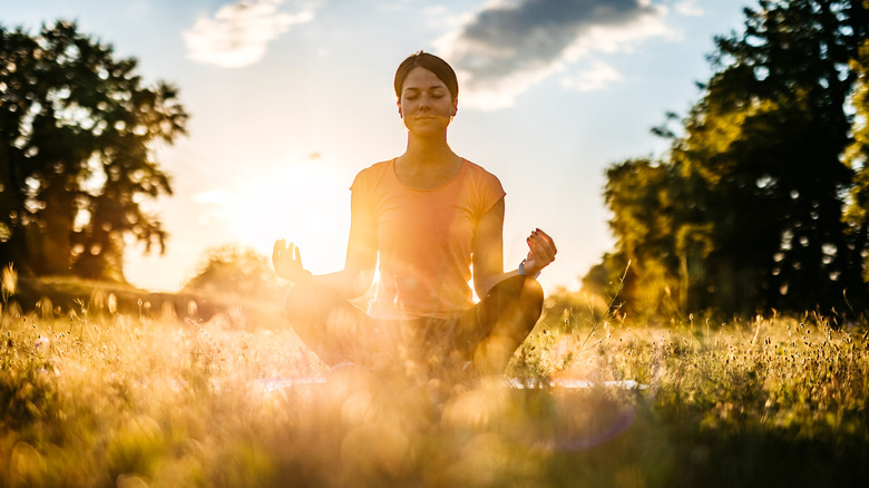 Woman doing yoga at sunset