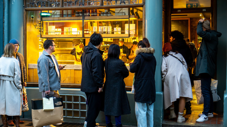 People queuing outside food shop