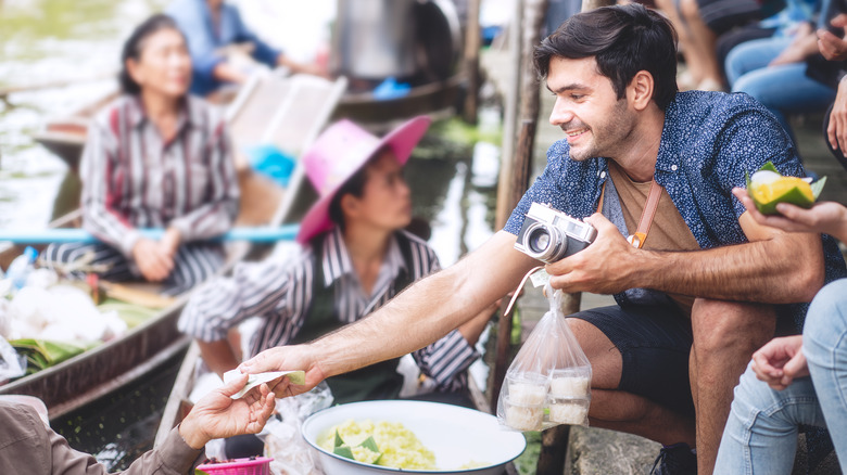 man purchasing food in Thailand