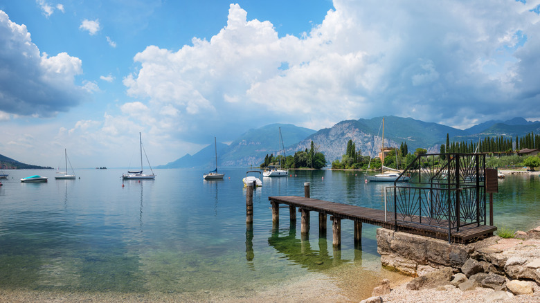 Sailboats and a pier on the water on Lake Garda in Italy