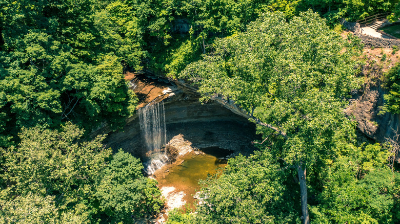 High waterfall cascading off limestone cliff