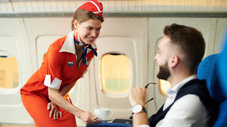 Flight attendant serving passenger