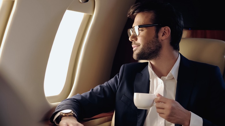 Man drinking coffee on airplane