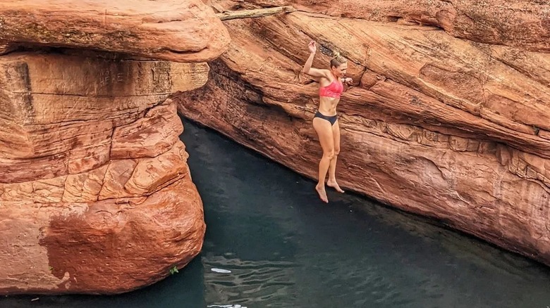 Girl jumping into rock pool
