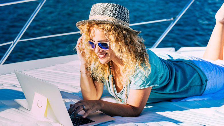 woman remote working on boat