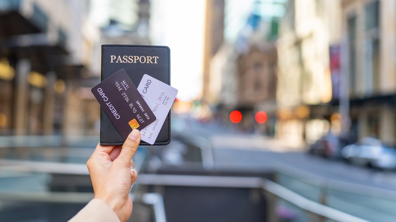 Hand holding passport, credit cards