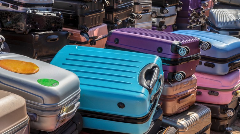 Piles of colorful suitcases stacked on top of each other