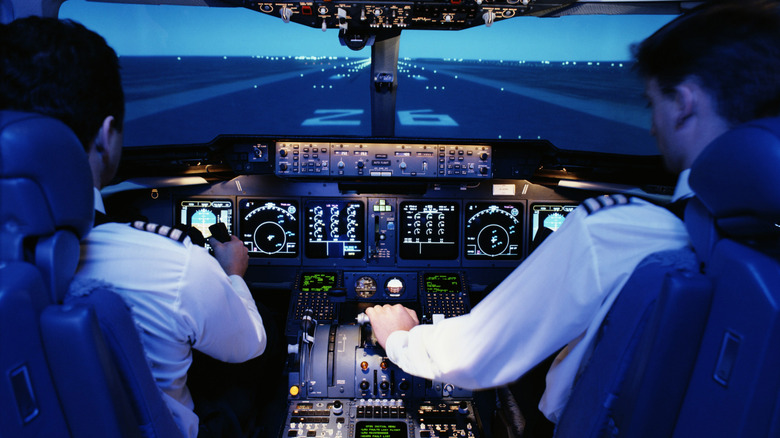 pilots in flight deck with view of control panel