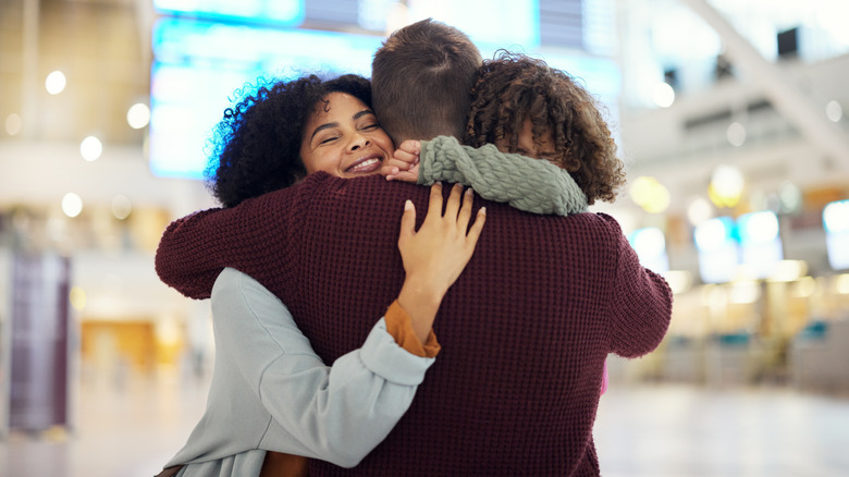 Family hugging at the airport